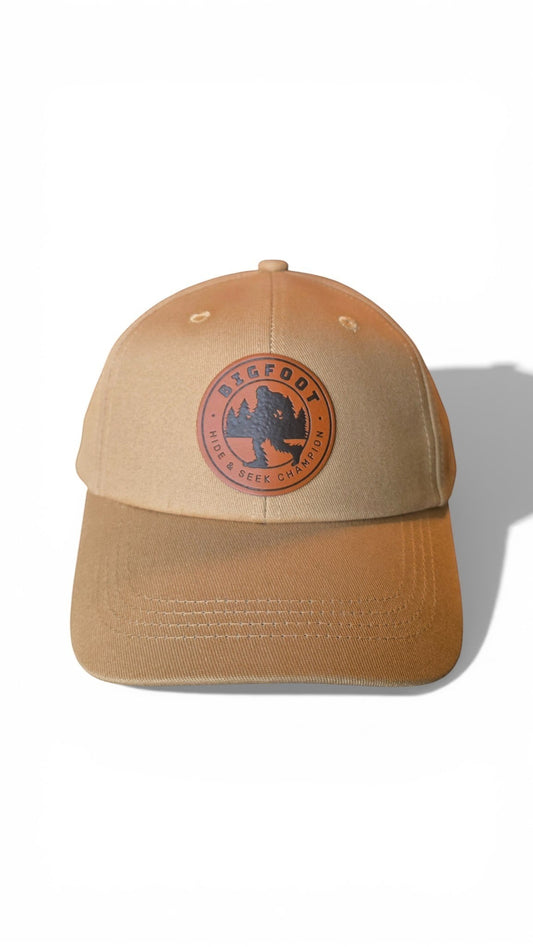 Moove Headwear tan trucker hat with Bigfoot Sasquatch leather patch and adjustable strap.