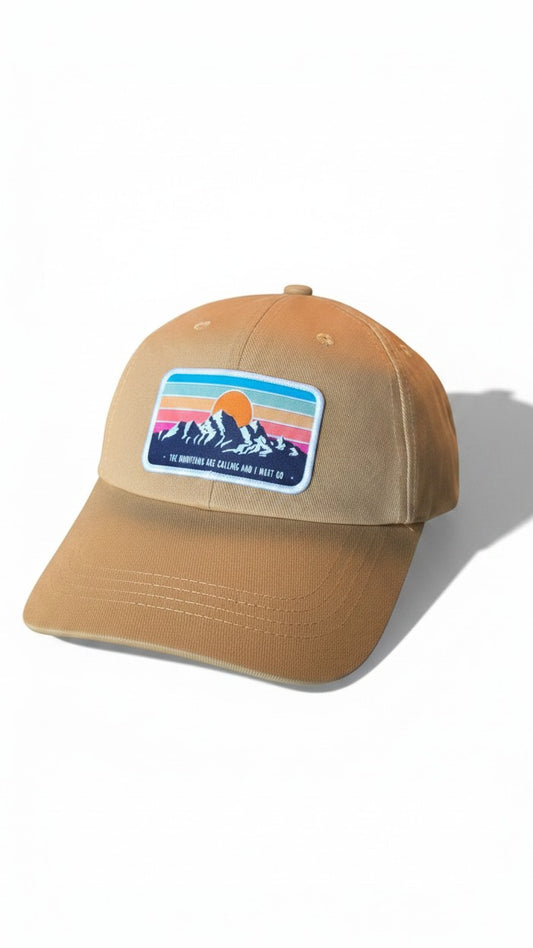 Moove Headwear tan dad hat with a retro mountain sunset patch. Adjustable brass buckle and hook and loop closure.