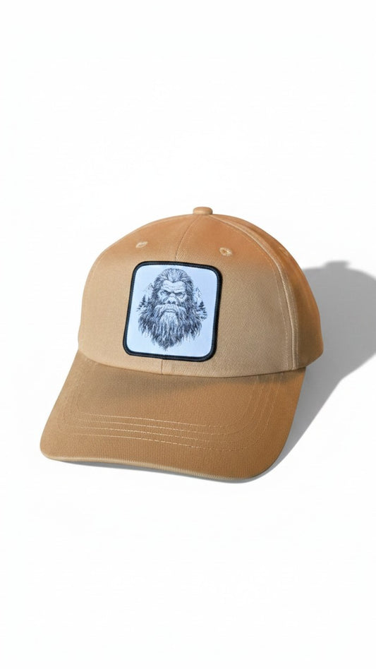 Moove Headwear tan dad hat with Bigfoot and trees patch, adjustable brass buckle and hook and loop closure.
