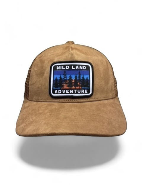 Moove Headwear brown suede trucker hat with mesh back and "Wild Land Adventure" patch, perfect for outdoor activities.