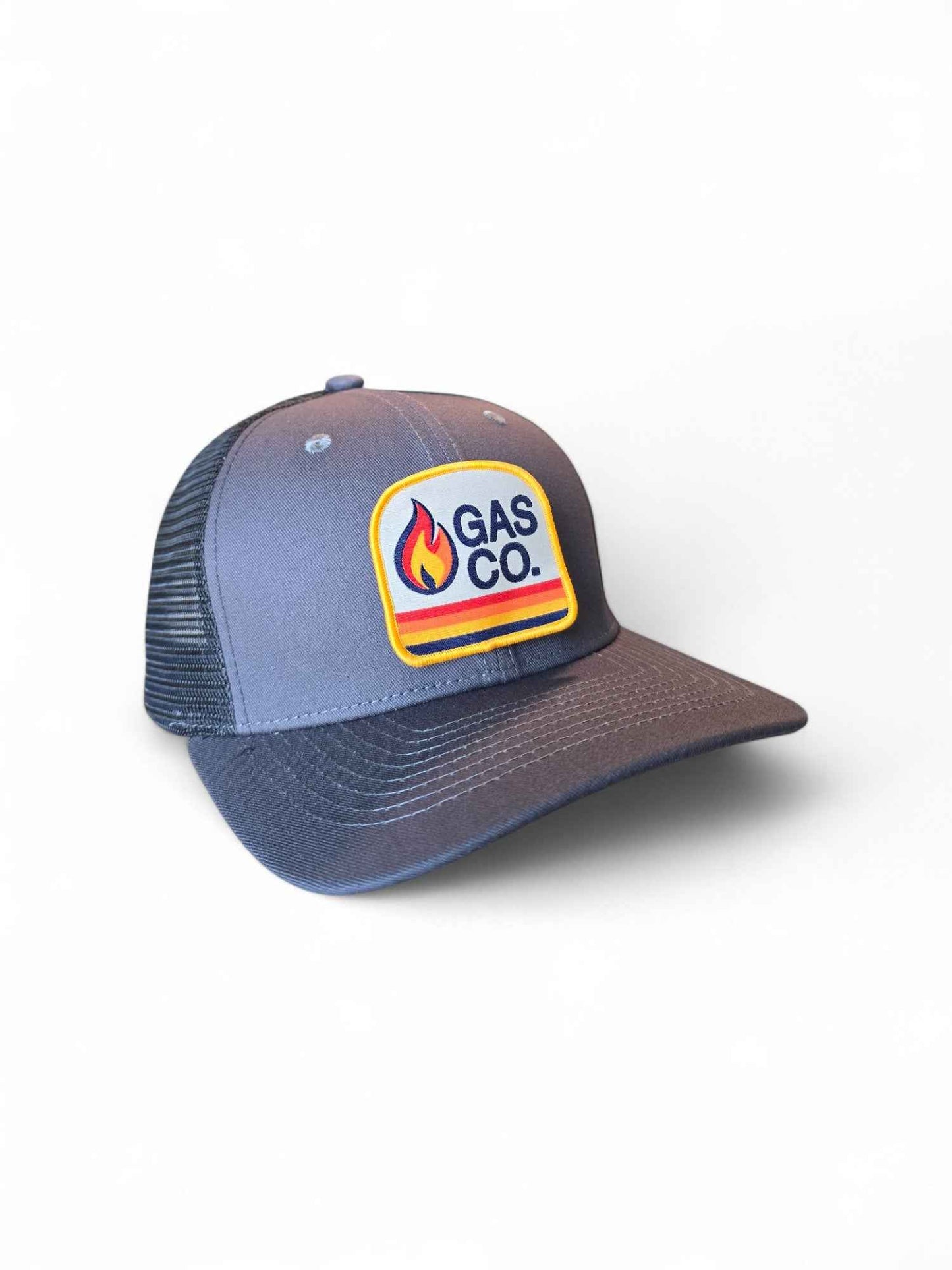 Gray and black retro trucker hat with Gas Co. flame patch, mesh back, and snapback closure