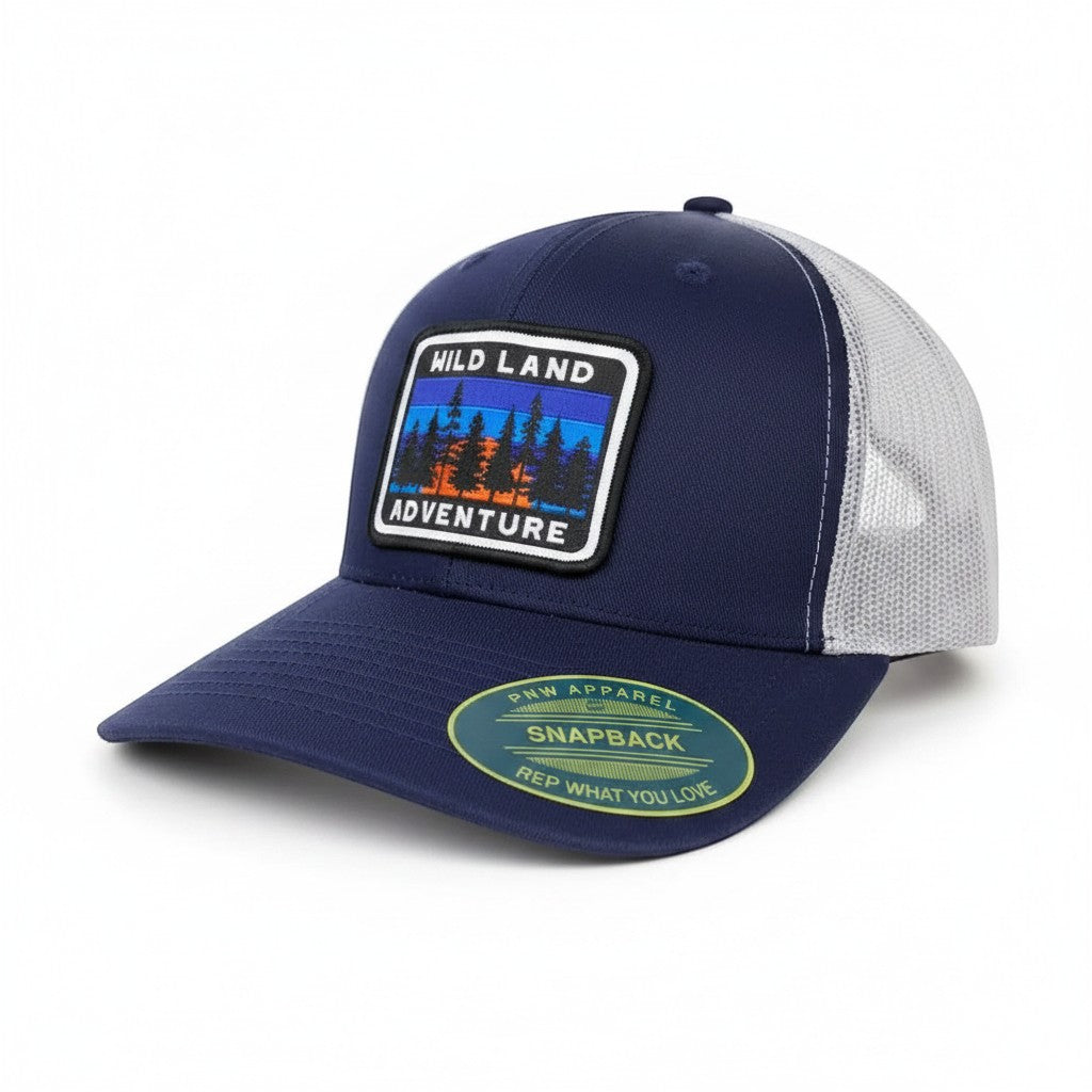 Moove Headwear navy blue trucker hat with mesh back and a patch depicting a forest landscape with the words "HILD LAND ADVENTURE"