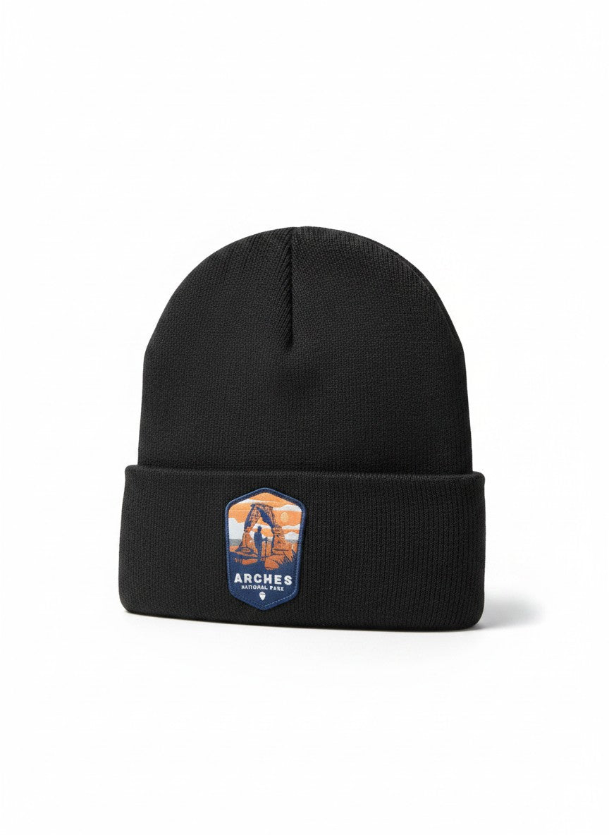Moove Headwear black knit beanie with Arches National Park patch featuring Delicate Arch and hikers.