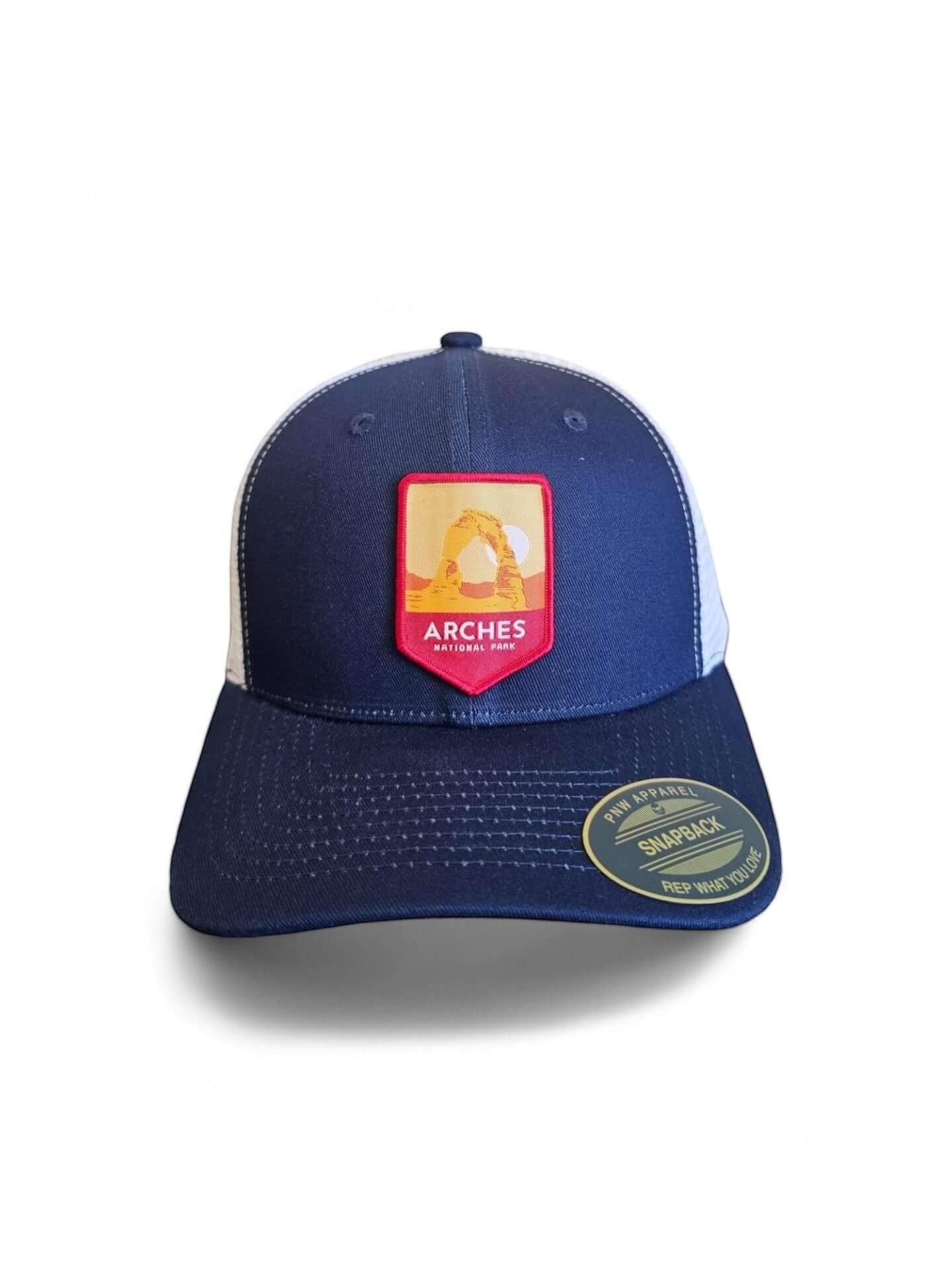 Moove Headwear navy blue trucker hat with Arches National Park embroidered patch and white mesh back.