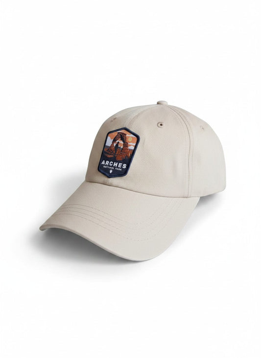 Moove Headwear tan baseball cap with Arches National Park embroidered patch, adjustable brass buckle closure.
