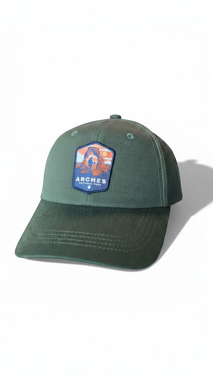 Moove Headwear green cotton baseball cap with Arches National Park embroidered patch, adjustable brass buckle closure.