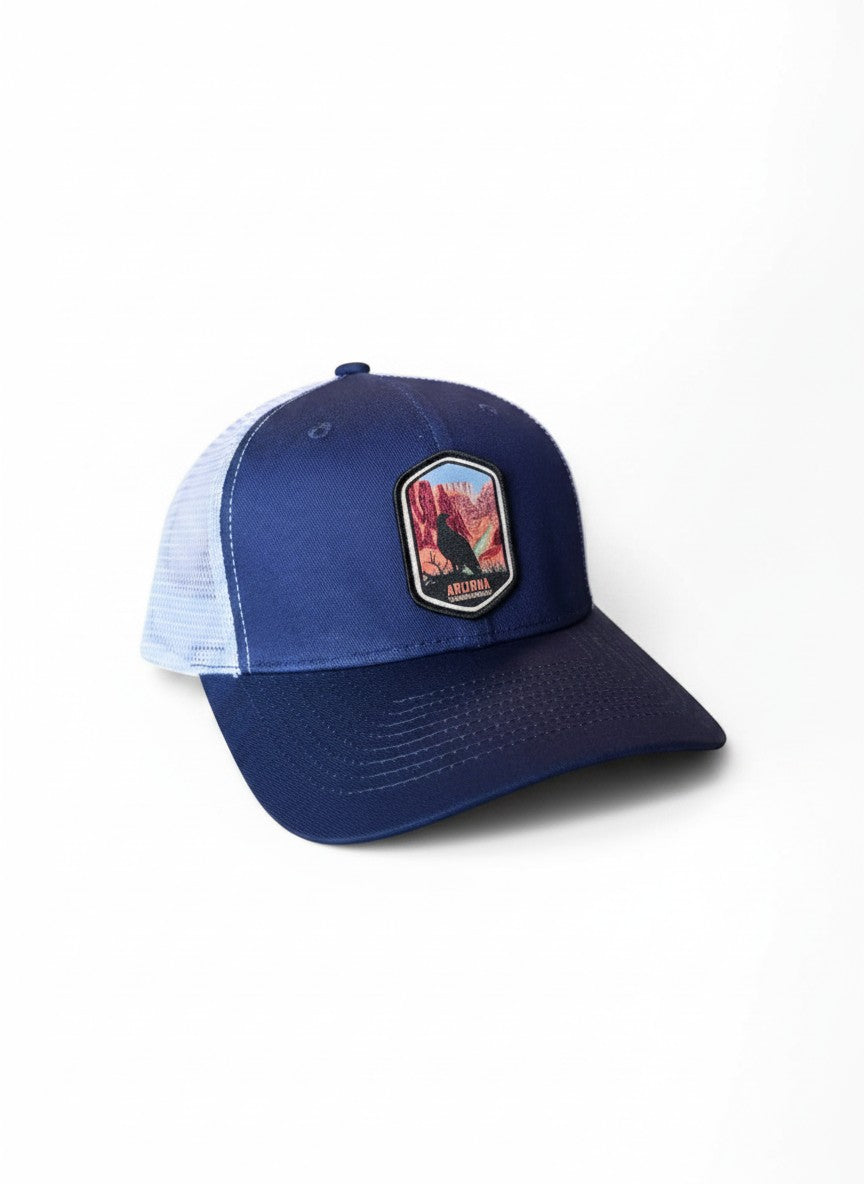 Moove Headwear navy blue trucker cap with embroidered Arizona desert patch and white mesh back.