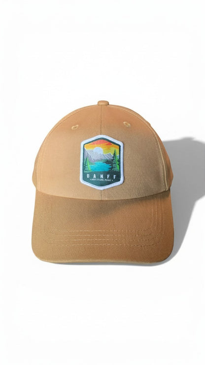 Moove Headwear Banff National Park embroidered baseball cap in tan with adjustable strap and mountain landscape patch.