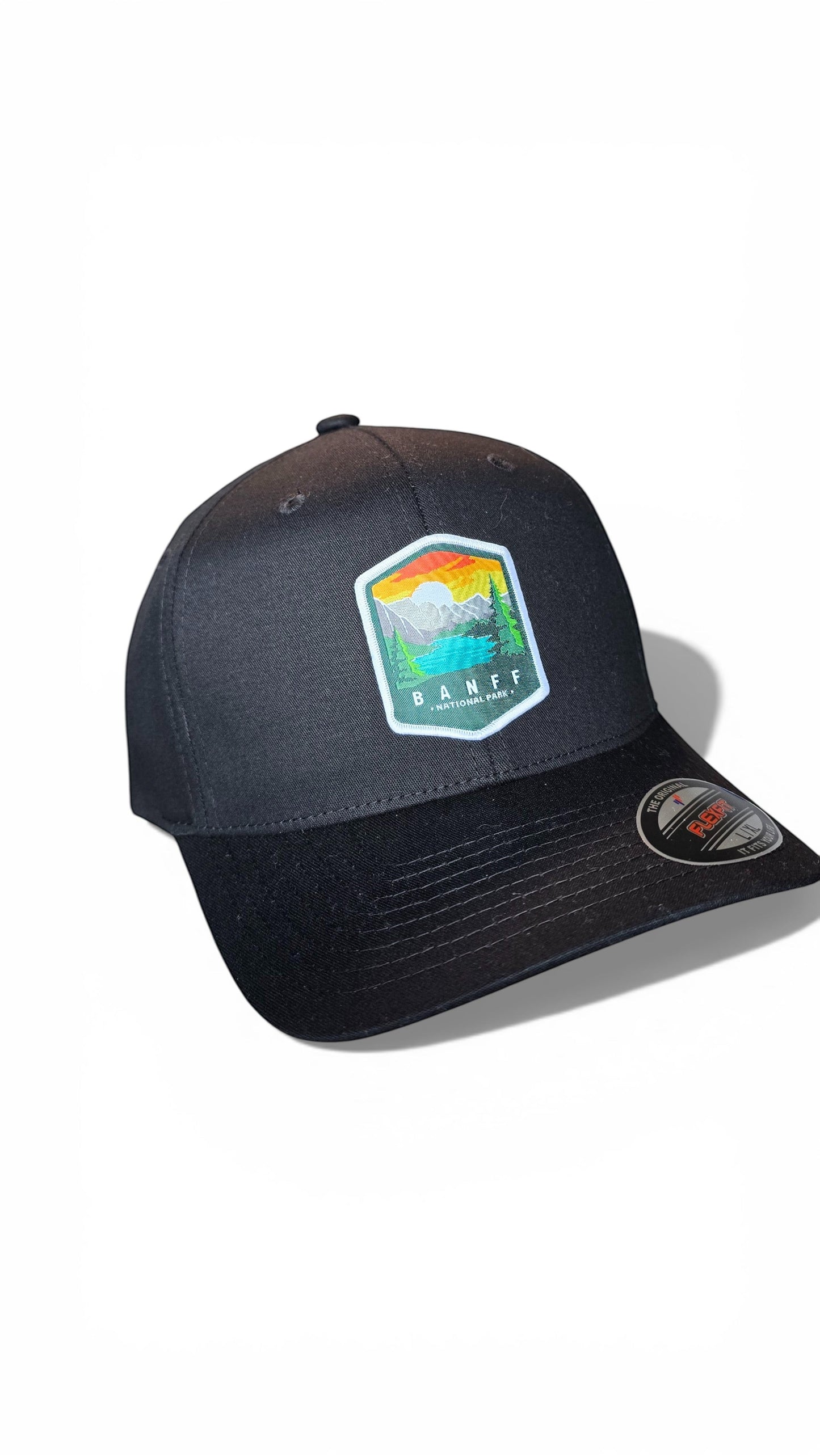 Moove Headwear black fitted cap with Banff National Park embroidered patch. Features a mountain and lake scene.