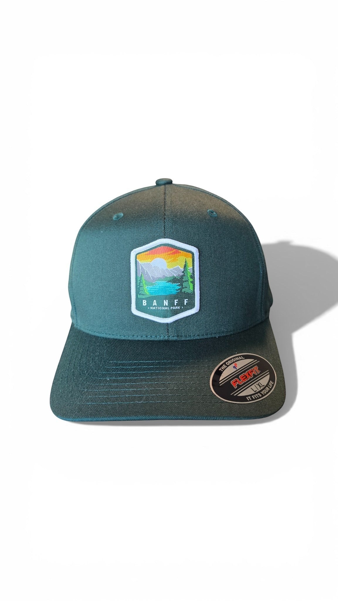 Moove Headwear Banff National Park fitted cap in dark green with a colorful embroidered patch of mountains, lake, and trees.