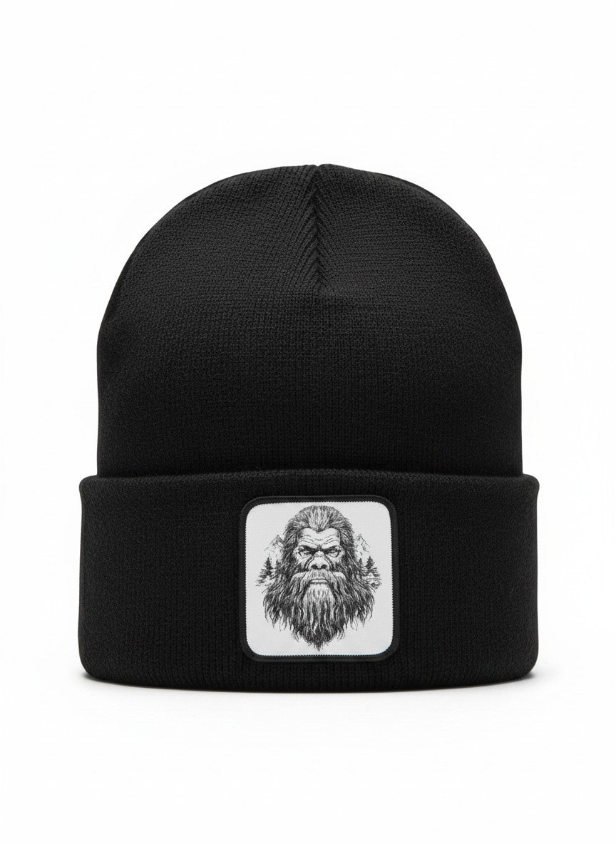 Moove Headwear black acrylic knit beanie with a woven patch featuring a Bigfoot illustration and pine trees.