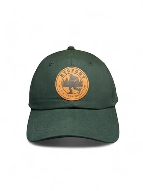 Moove Headwear dark green trucker hat with Bigfoot Sasquatch leather patch and adjustable closure.