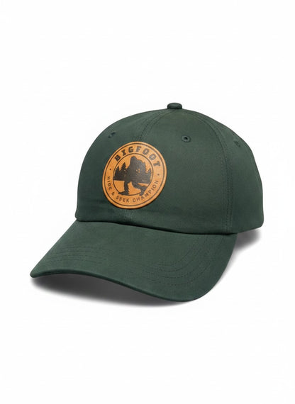 Moove Headwear dark green trucker hat with Bigfoot Sasquatch leather patch and adjustable closure.