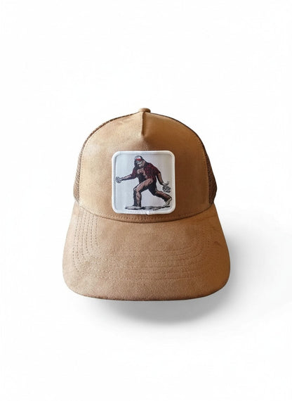 Moove Headwear tan suede trucker hat with Bigfoot graphic patch and mesh back. Adjustable snapback closure.