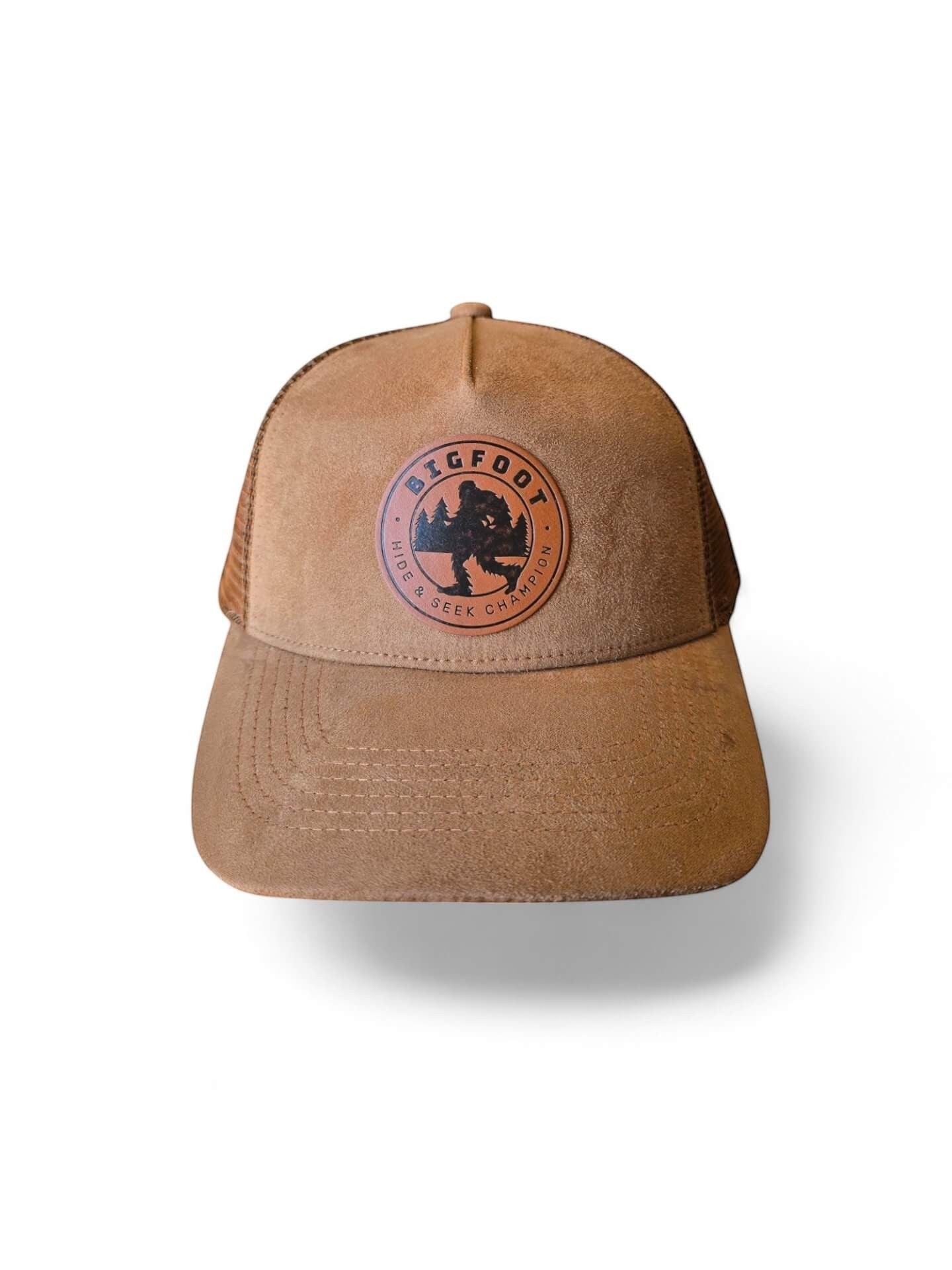 Moove Headwear tan suede 5-panel trucker hat with breathable mesh back and Bigfoot leather patch.