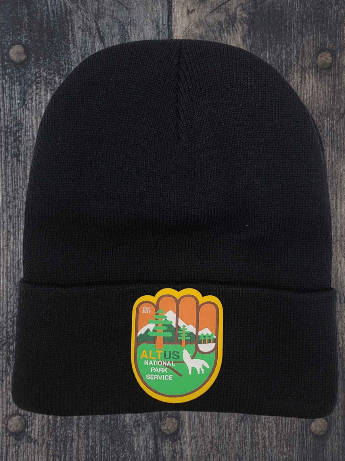 Moove Headwear black cuffed knit beanie with an AltUs National Park patch featuring mountain and forest graphics.