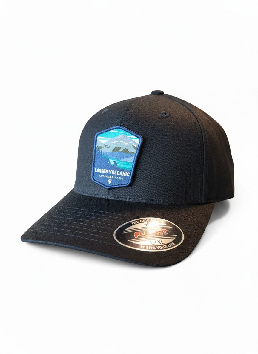 Moove Headwear black Flexfit cap with embroidered Lassen Volcanic National Park patch featuring mountains and forest.