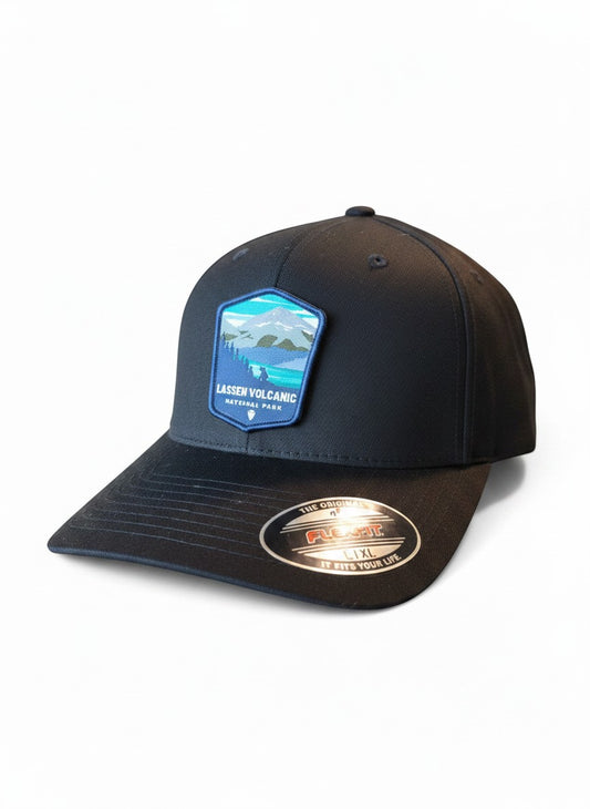 Moove Headwear black Flexfit cap with embroidered Lassen Volcanic National Park patch featuring mountains and forest.