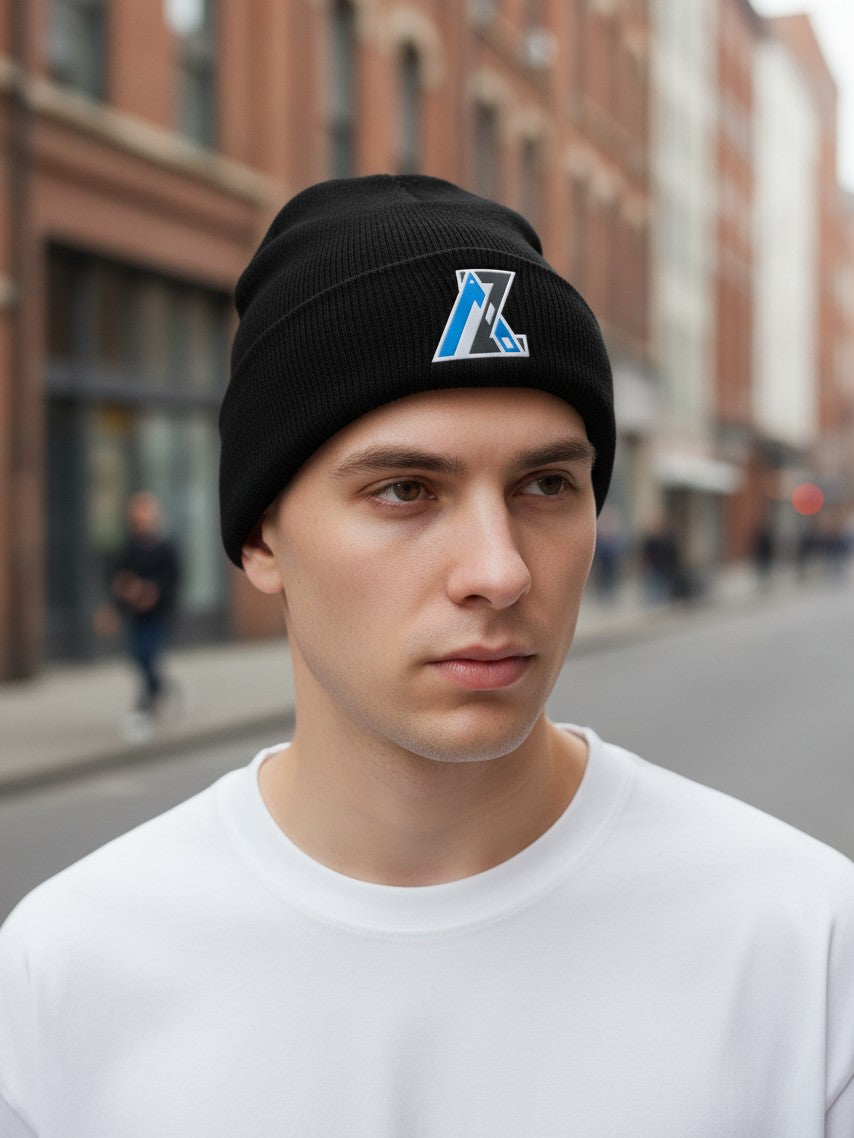 Moove Headwear black acrylic rib-knit beanie with a front woven patch worn by a man on a city street