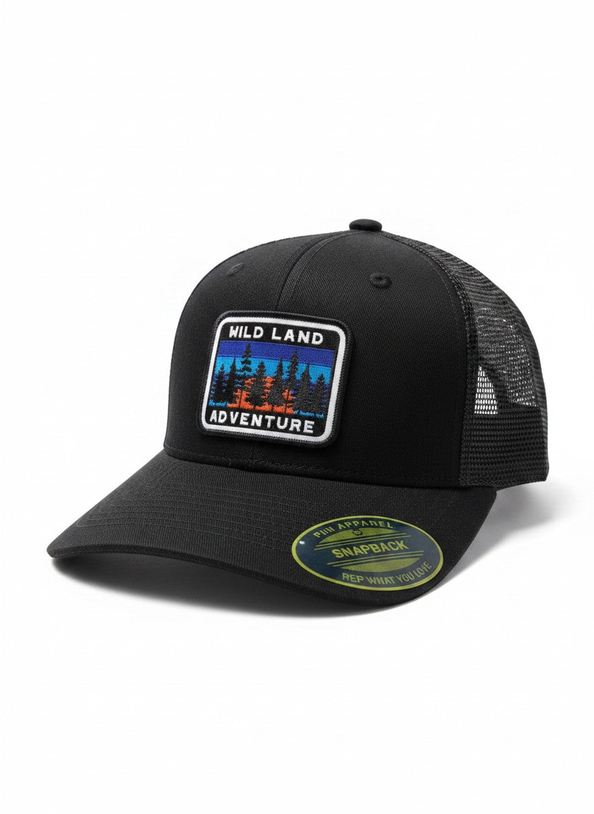 Moove Headwear black trucker hat with mesh back and "Wild Land Adventure" patch, adjustable snapback for outdoor hiking.