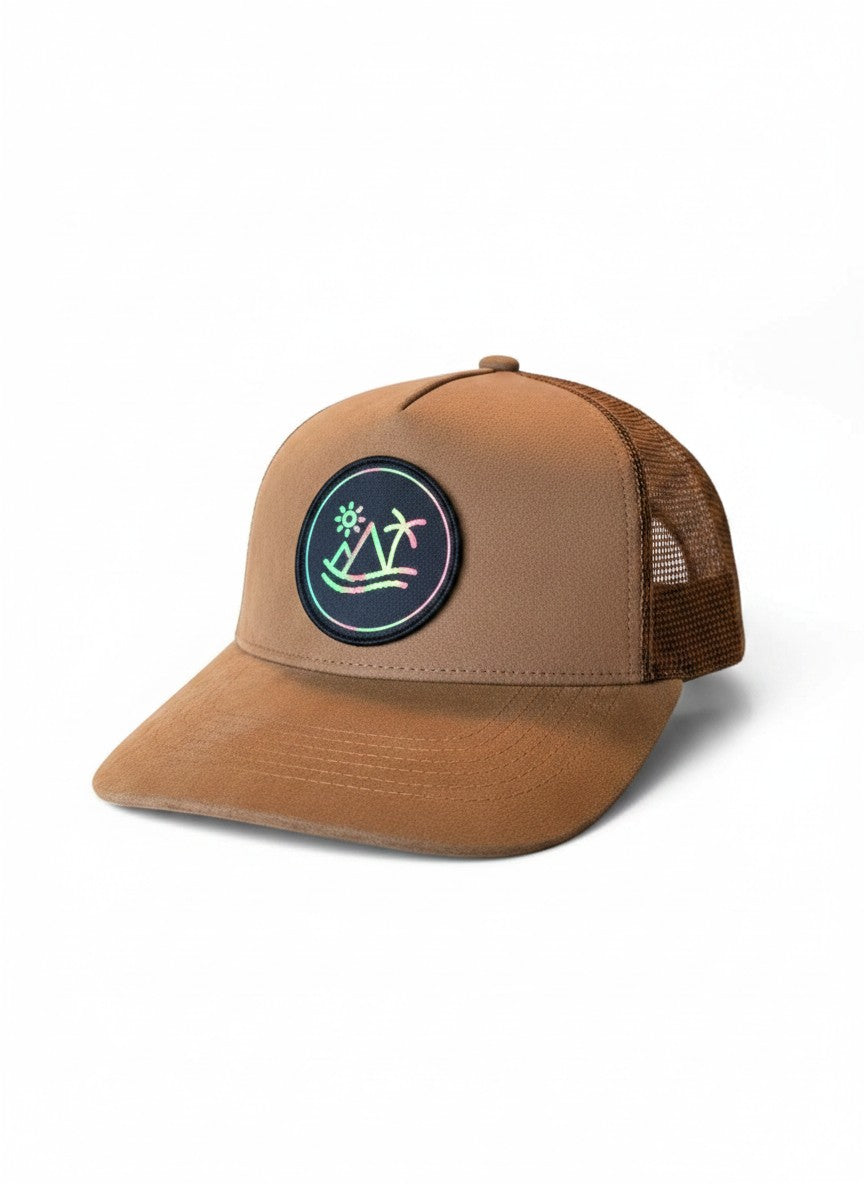 Moove Headwear brown suede trucker hat with breathable mesh back and circular patch featuring a sunset over mountains and palm trees.