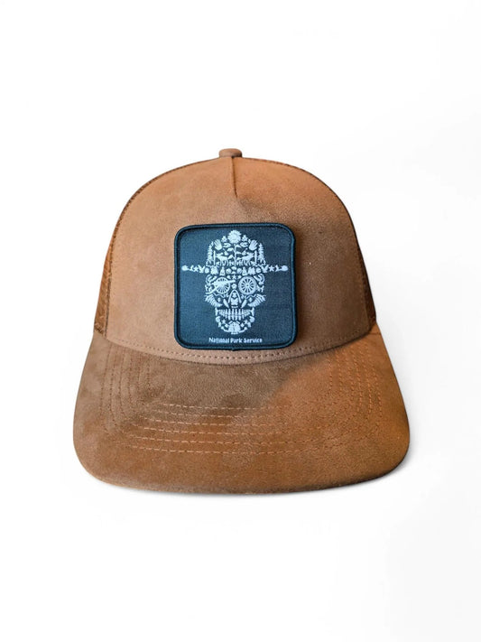 Moove Headwear brown suede trucker hat with mesh back and National Park Service skull patch. Adjustable snapback.