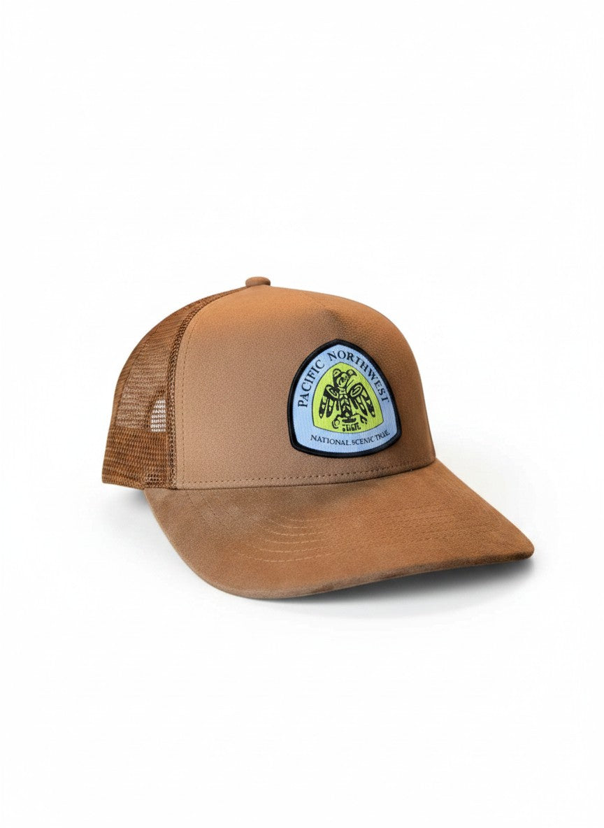 Moove Headwear brown suede mesh trucker hat with Pacific Northwest Trail patch and adjustable snapback closure.