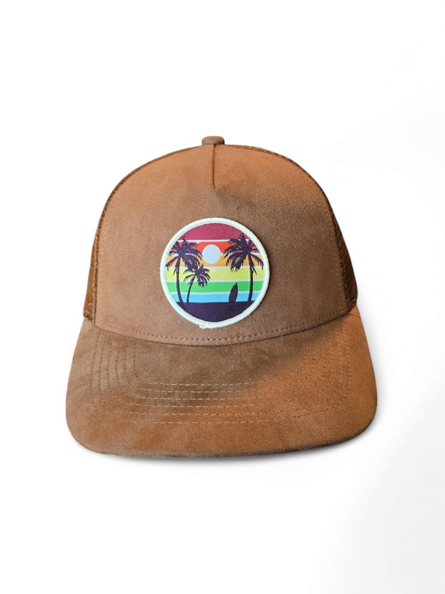 Moove Headwear brown suede trucker hat with mesh back and a circular patch featuring palm trees, a surfboard, and a rainbow sunset.