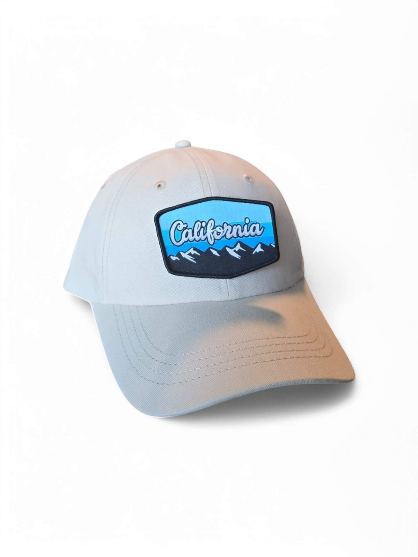 Moove Headwear light grey baseball cap with a "California Mountains" embroidered patch, adjustable fit, and sun protection.