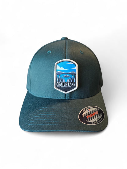 Moove Headwear Crater Lake National Park patch on a dark teal Flexfit cap with a structured crown and embroidered details.