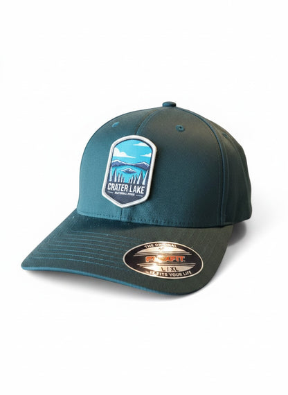 Moove Headwear Crater Lake National Park patch on a dark teal Flexfit cap with a structured crown and embroidered details.