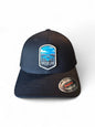 Moove Headwear black Flexfit cap with embroidered Crater Lake National Park patch featuring lake, mountains, and pine trees.