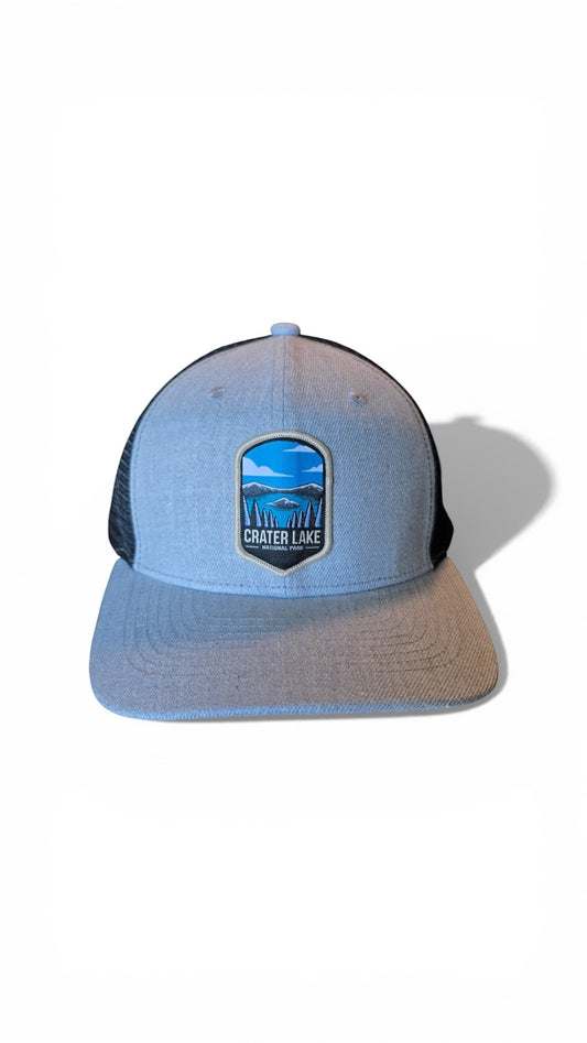 Moove Headwear light blue snapback hat with black mesh back and Crater Lake National Park embroidered patch.