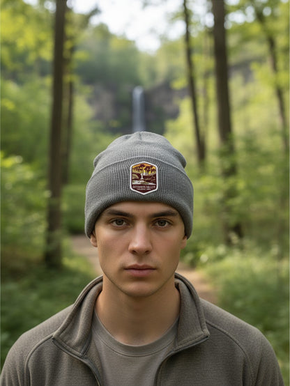 Man wearing a grey Moove Headwear beanie with a Cuyahoga Valley National Park patch in a forest setting.