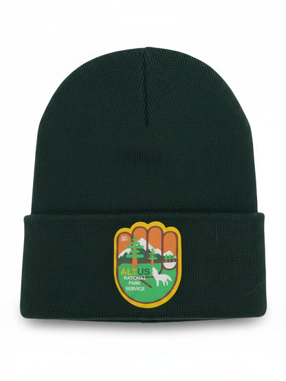 Moove Headwear dark green cuffed knit beanie with an AltUs National Park patch featuring a wolf and mountain design.