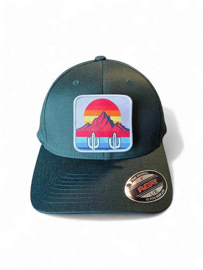 Moove Headwear dark green fitted hat with cactus and mountain sunset patch. Mid-profile structured crown.