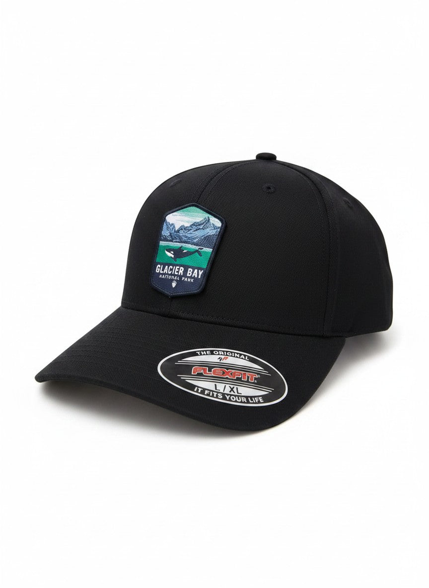 Moove Headwear black fitted hat with Glacier Bay National Park patch featuring a whale and mountains. Acrylic, cotton, PU spandex.