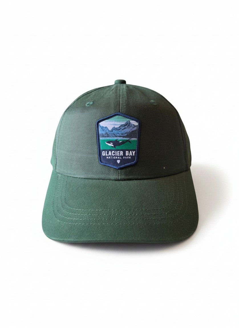 Moove Headwear dark green dad hat with Glacier Bay National Park whale embroidered patch. Adjustable strap.