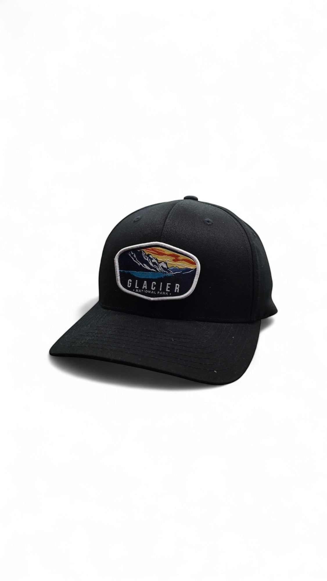 Moove Headwear black baseball cap with embroidered Glacier National Park patch featuring mountains and a lake.