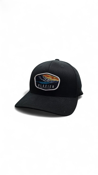 Moove Headwear black baseball cap with embroidered Glacier National Park patch featuring mountains and a lake.