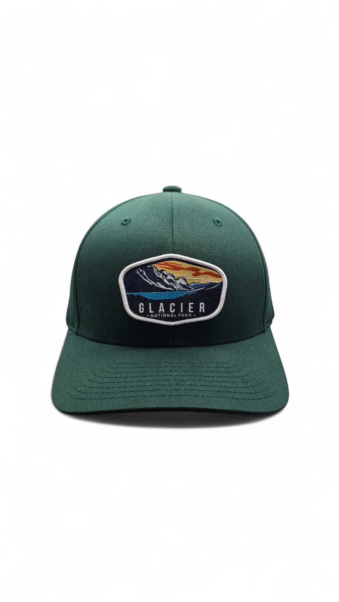 Moove Headwear dark green baseball cap with embroidered Glacier National Park mountain and lake scene patch.