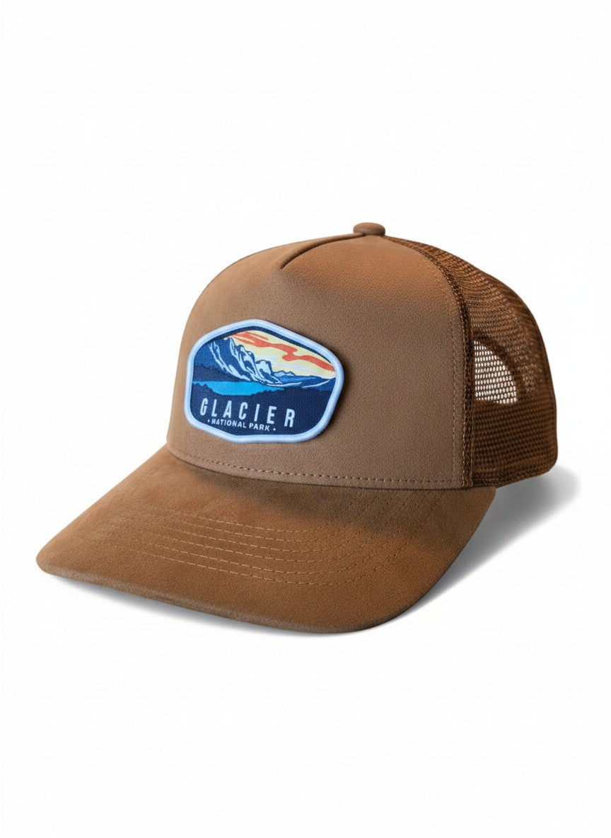 Moove Headwear brown suede trucker hat with embroidered Glacier National Park patch, mesh back, and 5-panel construction.