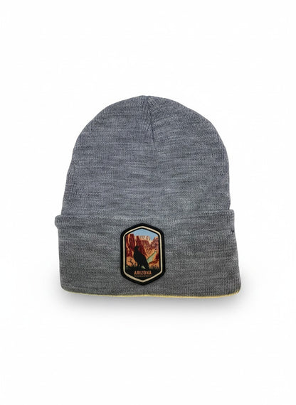 Moove Headwear grey acrylic rib-knit beanie with a woven patch featuring a bird and the Grand Canyon.