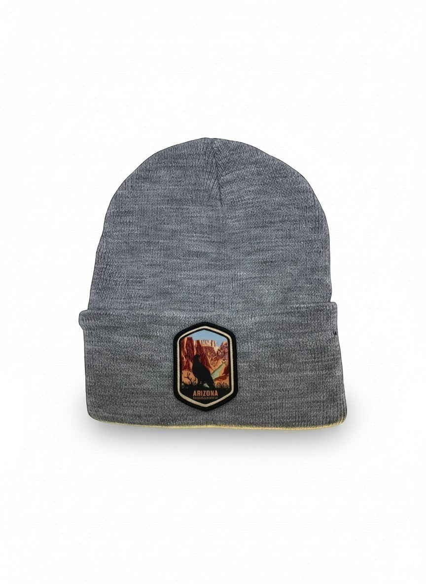 Moove Headwear grey acrylic rib-knit beanie with a woven patch featuring a bird and the Grand Canyon.