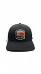 Moove Headwear black Flexfit cap with embroidered Grand Canyon National Park logo patch, featuring a sunset over the canyon and river.