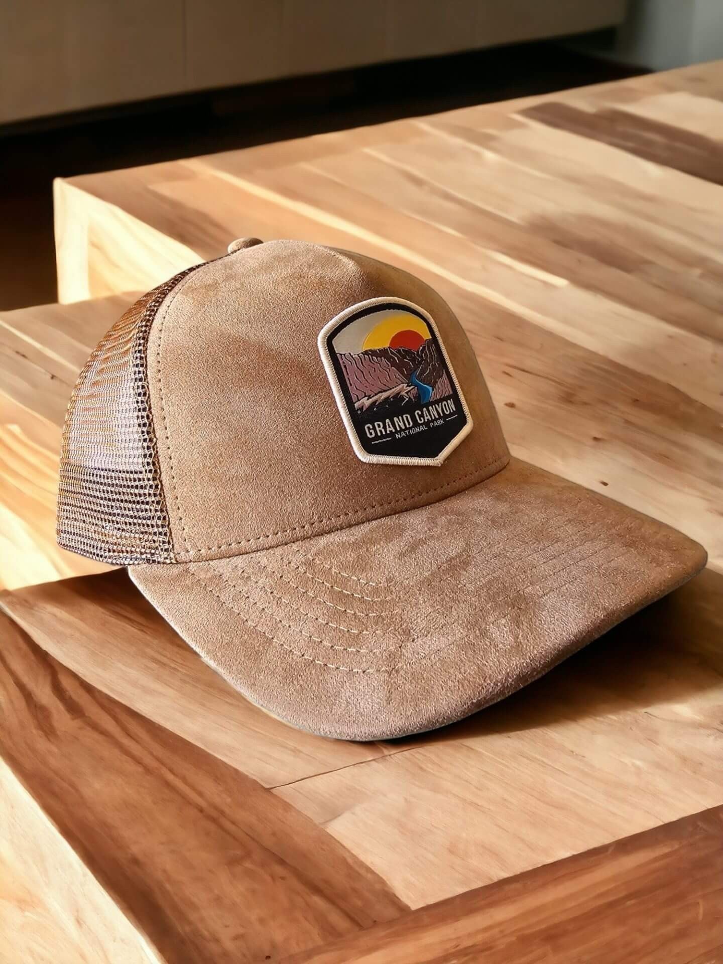 Moove Headwear tan suede trucker hat with Grand Canyon patch and mesh back panels. Adjustable snap closure.