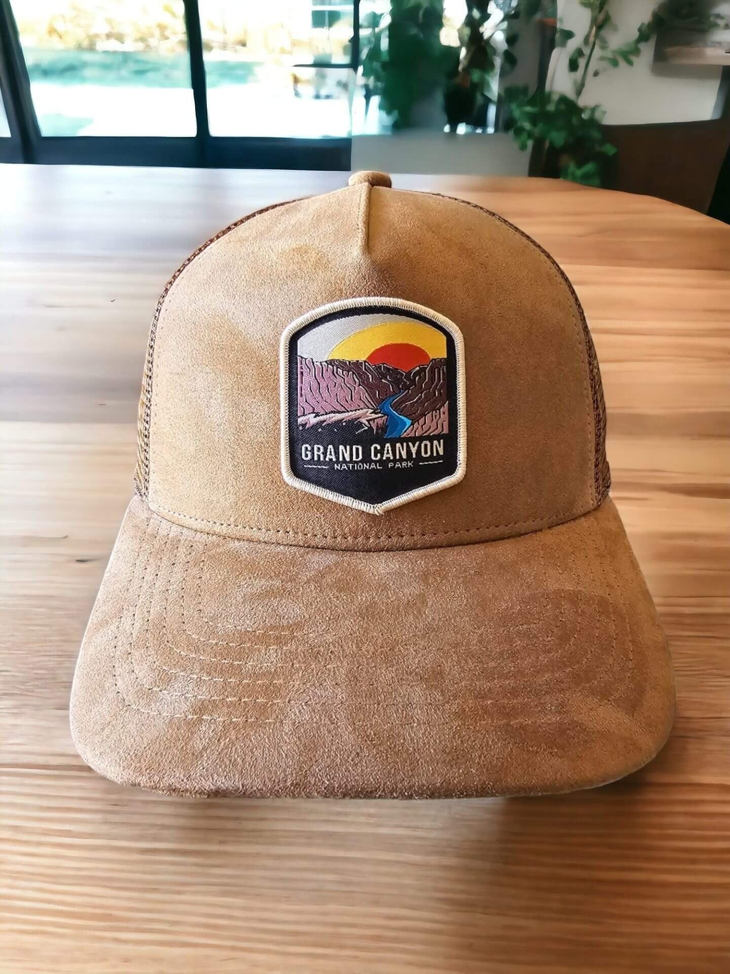 Moove Headwear tan suede trucker hat with Grand Canyon patch and mesh back. Adjustable snap closure.