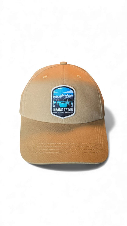Moove Headwear tan cotton dad hat with Grand Teton National Park embroidered patch and adjustable strap.