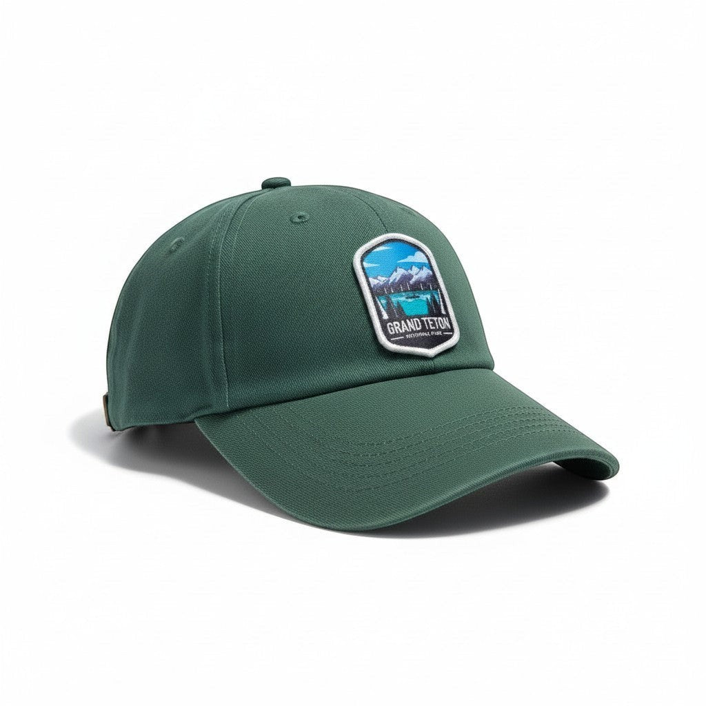 Moove Headwear Grand Teton embroidered dad hat in forest green cotton with adjustable strap and mountain landscape patch.