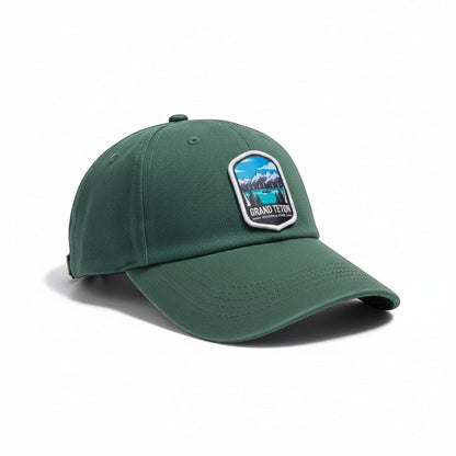 Moove Headwear Grand Teton embroidered dad hat in forest green cotton with adjustable strap and mountain landscape patch.